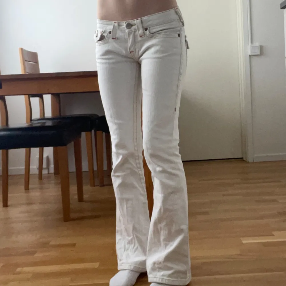 Tryck gärna på ”köp”!💗 Snygga lågmidjade vita True religion jeans med gula/orange stygn! Dom är bootcut/flare och i storlek 27. Midjemått ca 37 Innerbenslängd ca 74. Har en grå fläck på vänstra lår, se bild 5! Annars toppskick!💕 jag är 165. Jeans & Byxor.