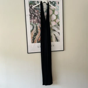 Svart aftonklänning  - Svart aftonklänning i storlek 38. Halterneck och djup rygg. Oanvänd 