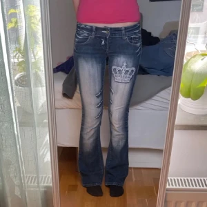 Lågmidjade crazy age jeans  - Säljer dessa lågmidjade bootcut crazy age jeans som är så y2k!🍸 de är strl 36, lite stretchiga, har vita fina kronor. Midjamått rätt över: 36cm innerben: 78cm! Fråga frågor i dm eller köp nu 🥰💗🙏🏼