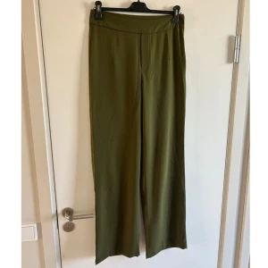 Vida kostymbyxor Bikbok - Gröna vida högmidjade kostymbyxor från Bikbok, stl 38. Dragkedja på ena sidan. 