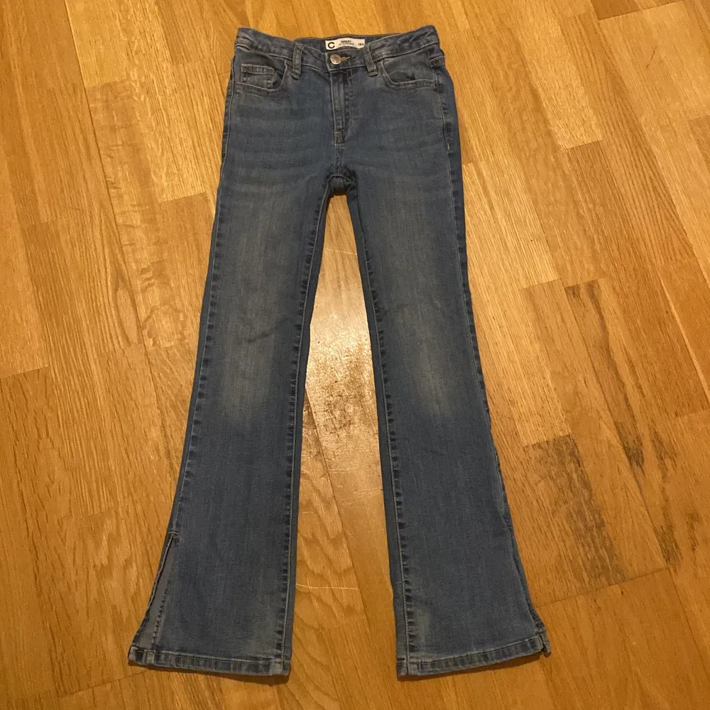 Säljer ett par snygga blå slit flare jeans från märket CubuS i storlek 152. De har en cool slitsdetalj vid bensluten och är i bra skick med bara några små tecken på användning. Perfekta för både vardag och fest! . Jeans & Byxor.