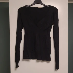 Svart långärmad tröja från Fashion One - Säljer en svart långärmad tröja från Fashion One i storlek S. Tröjan är tight och har en enkel design som passar perfekt till både vardag och fest. Materialet känns mjukt och bekvämt mot huden. Har tappat bort bandet.