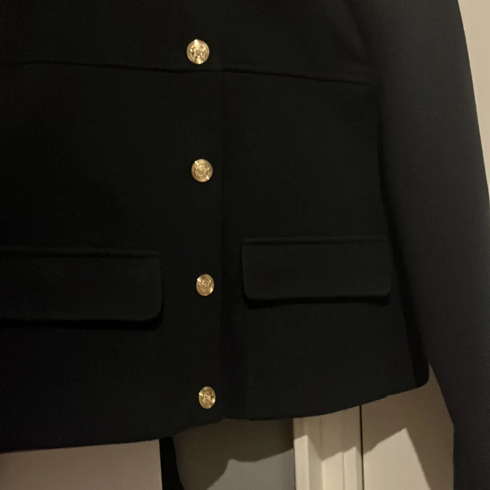 Säljer en snygg mörkblå kavaj från Zara.kag köpte den för 600kr och har använt den 2-3 gånger. säljer den för vill köpa en ny!Den har guldknappar fram och på axlarna. Kavajen är croppad och har en normal passform. Perfekt för både. Takit.