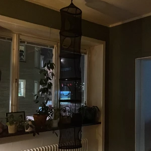 Hängande förvaring - Svart hängförvaring i nät med hål för varje plan .