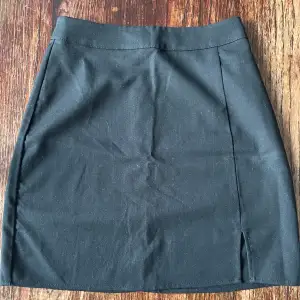 En svart tajt kjol ifrån Bikbok med slits 