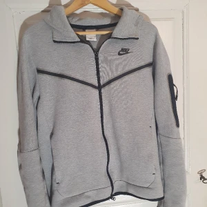 Nike tech fleece grå S - Jag säljer min gråa nike tech fleece. Är sparsamt använd. Är i storlek small. Är inköpt i nike butiken på mos för 1200kr. Pris kan diskuteras
