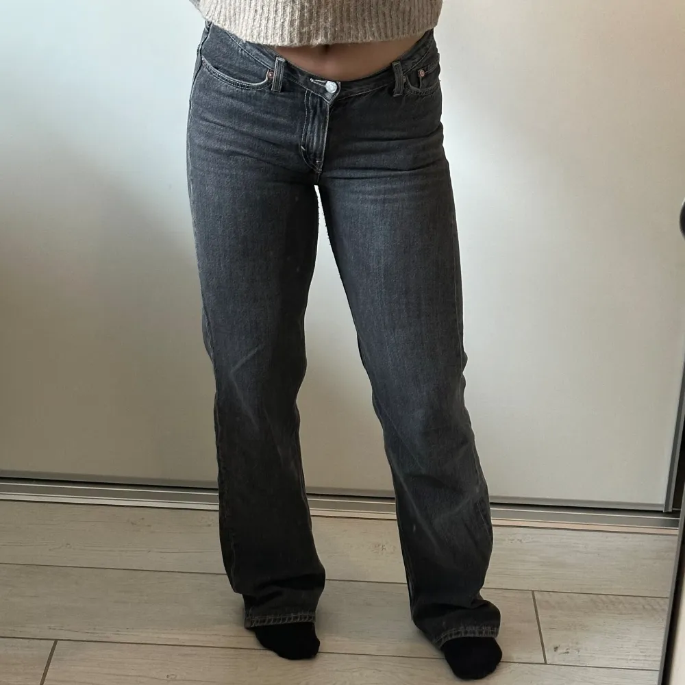 Mörkgråa lågmidjade raka jeans från Weekday med ljusa sömmar. Storlek 27. Slitna längst ner på benen på baksidan men det är inget man tänker på när man väl har på dem. . Jeans & Byxor.