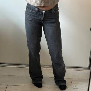 Mörkgråa lågmidjade raka jeans från Weekday med ljusa sömmar. Storlek 27. Slitna längst ner på benen på baksidan men det är inget man tänker på när man väl har på dem. 