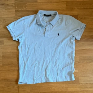 RALPH LAUREN PIKÉ  - Fin ljus blå ralph lauren piké som är perfekt inför sommaren, knappt använd. NYPRIS:1300❗️ Mitt pris: ENDAST 199✅