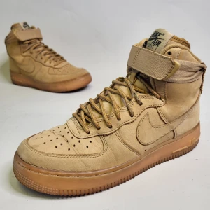 Nike Air Force 1 High Flax Storlek 38.5 Sneakers Skor Beige - 14 dagars ångerrätt! Skorna har tecken från användning men annars är de i bra skick. Inga hål på utsidan eller insidan. Ingen dålig lukt. Hör av dig om du har några frågor! Tack för att du tittade!