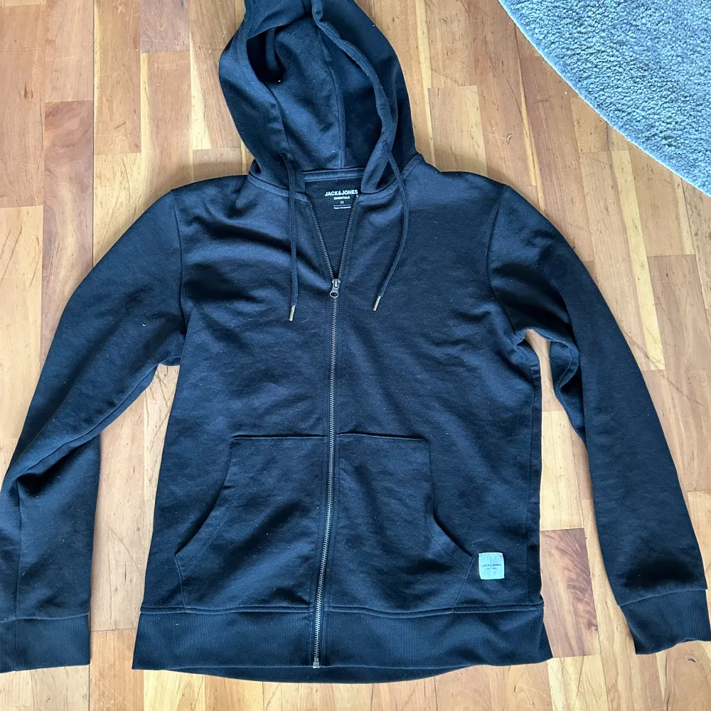 En svart zip hoodie från jack & jones i storlek M. Säljer då den inte längre kommer till användning. Den är använd sparsamt hör gärna av er vid frågor eller för fler bilder. Hoodies.