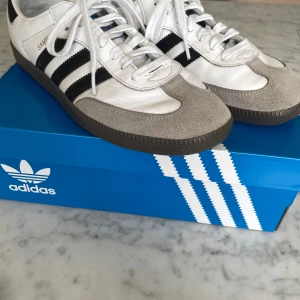 Adidas samba OG vit - Ett par adidas samba OG i vitt. Skicket är  använt men dom ser ändå helt okej ut. Storlek är 43, 1/3. Skulle säga att om du brukar ha något mellan 41,5-43 att det skulle passa bra. Kartongen följer även med!! Köpta för ca 1400kr