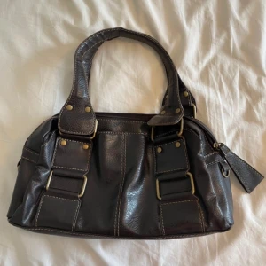 Vintage väska - Supersnygg vintage handväska i äkta läder. Den är lite trasig på ena handtaget men det är inget som syns jättemycket. Skulle säga att den är svart eller mörkbrun 🖤lånade bilder