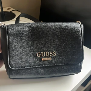 Guess väska - En fin, svart axelremsväska från Guess i bra skick. 