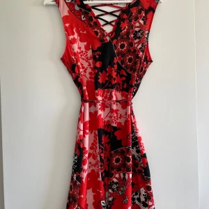 Mönstrad klänning  - Röd mönstrad klänning från river island, storlek 36. Använd men utan anmärkningar. 