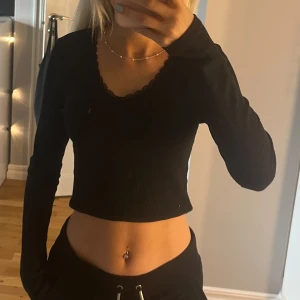 Svart långärmad med spets urringning  - Säljer denna långärmade tröjan med spets urringning. Den är som i nyskick då jag endast användt den en gång . Den är ganska tunn och sitter ganska tajt så den sitter som strl säger 