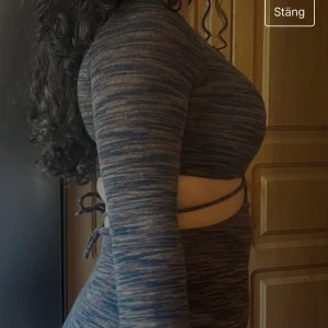 Mörk långärmad klänning - En mörk långärmad klänning med en tight passform. Klänningen har en unik design med utskärningar vid midjan och en omlott-detalj framtill. 💕