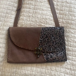Äkta läder väska med leopard mönster - Väskan är helt oanvänd och har ett fint glittrigt leopard mönster.