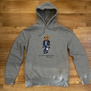 Ralph Lauren Hoodie - Polo Ralph Lauren Bear Hoodie (Äkta). Den är i perfekt nyskick. Fick den i julklapp förra året men jag har ej använt den vilket är synd för det är en väldigt fin Hoodie i extremt bra kvalitet. Nypris är runt 2395kr säljer den för 695kr! 
