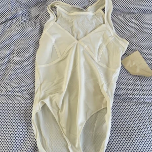 Vit body med detaljer - En vit body med detaljer från minx lite genomskinlig men inget som märks mycket