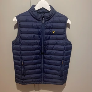 Lyle & Scott Väst - Lyle & Scott väst i nyskick. Endast använd vid fåtal tillfällen. Är storlek 16 years men sitter som XS/S. Säljer billigt då den inte kommer till användning.