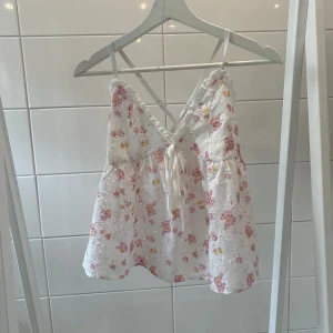 Sommarlinne  - Sommarlinne med korsat snöre i ryggen aldrig använt så nyskick. Storlek s men stretchig. Konstig form på bilden men sitter tajt upptill och går ut.