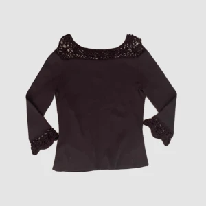 Svart topp med spetsdetaljer - En elegant brun topp med långa ärmar och spetsdetaljer runt halsen och ärmsluten. Toppen har en åtsittande passform och är perfekt för både vardag och fest.