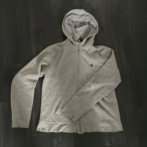 Grå Ralph lauren fullzip - Den här grå Ralph lauren zipen är i 9/10 kvalitet för den har använts några gånger men det finns noll defekter på den🥂 Jag köpte den för 1399 men säljer den för mycket billigare🔥Den passar både Xs och S och hör av er om ni har någon fråga🌟