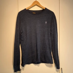 Ralph Lauren Långärmad T-shirt - Hej, säljer en fräsch långärmad t-shirt från Polo Ralph Lauren i mörkblå färg. Fint skick, sparsamt använd. Storlek M och passar även S. Snygg blå skiftande färg som passar till allt. Nypris 1500kr. Pris kan diskuteras. Hör av dig vid intresse! 