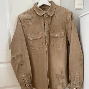 Jeansjacka Zara - En otroligt snygg jeansjacka ifrån Zara i färgen brun. Sparsamt använd och bra skick. Jackan saknar dock tyvärr den 2:a knappen uppifrån, därav priset. Storlek: M