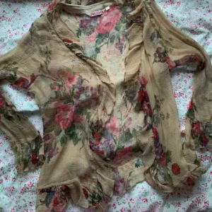 blommig mesh topp - den har ett hål som syns på bilden