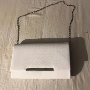 Väska  - Jätte fin väska som tyvärr inte kommer till användning längre, den har ett litet fack på insidan och avtagbar kedja Väskan är ungefär 22 x 14 och kedjan är 70 cm lång Köpt för 399kr