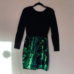 New Yorker paljettklänning - Paljettklänning köpt på New Yorker för säkert 8 år sedan nu. Man kan vända på paljetterna och skifta färg från grön/blå till svart. Öppen rygg. Använd en gång, i nyskick utan anmärkningar. Väldigt bekväm 🌹