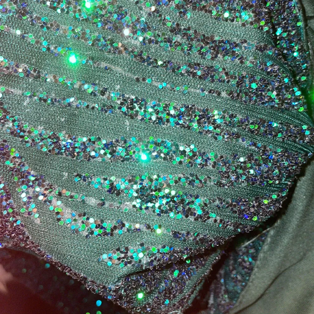 Blågrön glittrande klänning köpt på bella barnett för 4 år sen men användts endast en gång. Funkar till större fester då den är lite dyrare☺️pris kan diskuteras vid snabb affär. Klänningar.