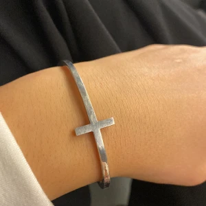 Silver armband med kors - Hejsan! Jag säljer nu mitt korsarmband av märket folli follie för 350 kr men vid originalpris lite över 500kr. Jag har använt det mycket så det är i använt skick. Går att ändra storleken där bakom. Skriv om ni har frågor!