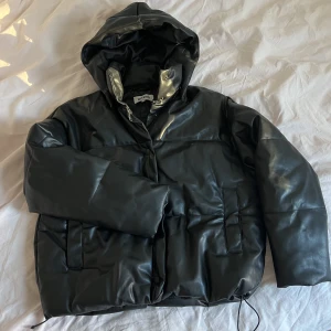 Pufferjacka från WEEKDAY  - Jacka i PU-leather. I fint skick. Försluts med knappar, har två fickor + 1 innerficka, dragsko i midjan. Varm och skön jacka! 100% polyester🩷