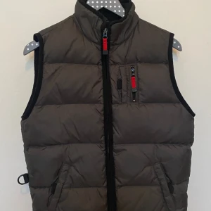 Dunväst - Västen är perfekt till våren man kan ha en hoodie under vilket också gör det varmare. Västen är inte använd mycket och är i väldigt fint skick.🥰det står att den är för barn men själv skulle jag säga att den passar ungdomar också👌🏼