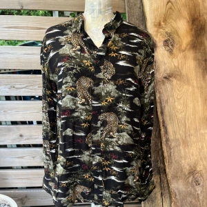 Cool skjorta i viskos - Härligt skön skjorta i viskos, coolt mönster med tigrar. Märkt stl S herr stl. Men jag har anv den som dam stl 38-40. Skulle säga unisex. Använd men i fint skick.