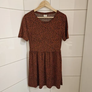 Klänning (Nyskick) Strl S - Klänning  Strl S Nyskick! Färg: Rost, Svart Jacqueline de Yong  Superfin klänning i smickrande modell med leopardmönster. Otroligt skön och sval. Endast använd två ggr.