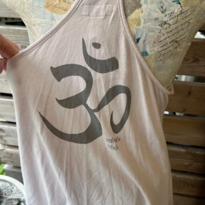 Nytt! Härligt linne med aum tecken från Ajlajk  - Super fint linne i härlig bomull, flätade band och fin passform, lite a-linje format. Såg när jag fotade att det fanns en pytteliten ljus fläck (ser ytlig ut så det är nog inga problem att få bort) nypris 499;-