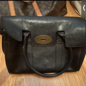Mulberry väska - Svart väska från Mulberry med serienummer 026904. Väskan har trasigt lås, går säkert ock fixa och ena handtaget har släppt något. Se bilder noggrant. Längd 33 cm, lite mindre än Bayswater.  Bra starkt läder! .    