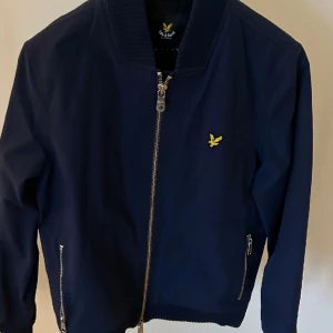 Vårjacka - Säljer en jättefin marinblå bomberjacka ifån lyle and scott. ALDRIG ANVÄND!! Nypris ca 1299kr men säljes endast för 749kr. Pris går att diskutera vid snabb affär! Skick 10/10