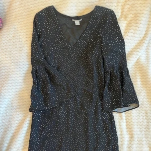 Prickig klänning - Fin prickig klänning med v-ringad hals. Sparsamt använd!