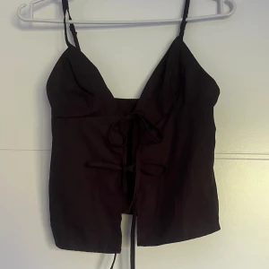 Topp med rosetter - Jättefin topp med knytningar framtill. Aldrig använd😍.