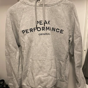 Peak Performance hoodie  - Grå hoodie från Peak Performance. Använd men fint skick. XL men anser att den är lite mindre. 