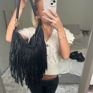 Svart väska med fransar - Säljer denna svarta väska med fransar. Den är ganska sliten, därav priset. Har du någon fråga är det bara att höra av dig🫶🏻