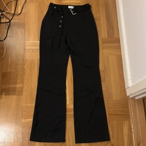 Kostymbyxor - Svarta kostymbyxor med skärp från nakd