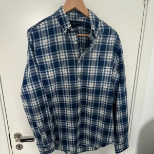 Flanell skjorta - Rutig flanell skjorta från Ralph Lauren i färgen blå och vit. Inga defekter så bara att höra av sig om det är något du undrar över