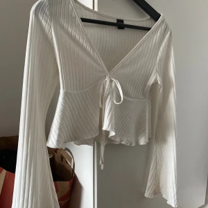 Vit tröja med utsvängda ärmar - Säljer denna fina tröja från shein med ett snöre och utsvängda ärmar! Använder inte denna då den är lite cropad i passformen och det är inte min stil.