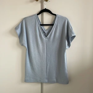 Topp  - • Glansig i färgen  • Isblå färg 